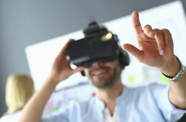 Young male software programmer testing a new app with 3d virtual reality glasses in office.