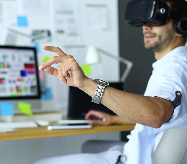 Young male software programmer testing a new app with 3d virtual reality glasses in office.