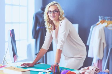 Moda tasarımcısı kadın stüdyoda tasarımları üzerinde çalışıyor..