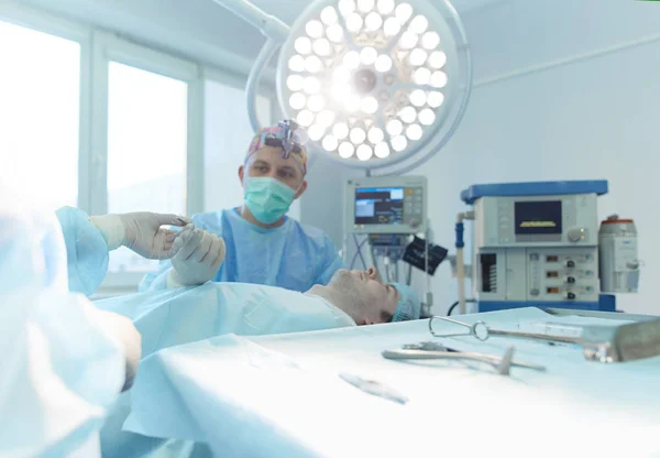 Homem cirurgião no trabalho na sala de cirurgia — Fotografia de Stock