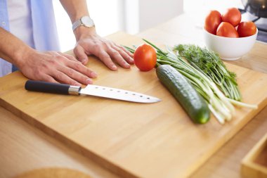 Adam ev mutfağında lezzetli ve sağlıklı yemekler hazırlıyor.