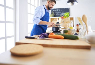 Adam ev mutfağında lezzetli ve sağlıklı yemekler hazırlıyor.