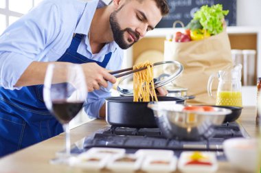 Adam ev mutfağında lezzetli ve sağlıklı yemekler hazırlıyor.