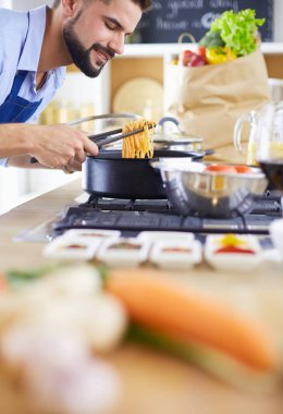 Adam ev mutfağında lezzetli ve sağlıklı yemekler hazırlıyor.