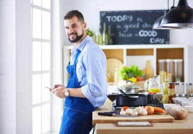 Mutfak arka planında poşet dolusu erzak tutan adam. Alışveriş ve sağlıklı gıda konsepti