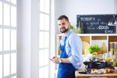 Mutfak arka planında poşet dolusu erzak tutan adam. Alışveriş ve sağlıklı gıda konsepti