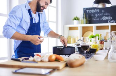 Adam ev mutfağında lezzetli ve sağlıklı yemekler hazırlıyor.