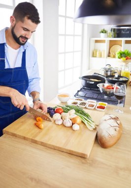 Adam ev mutfağında lezzetli ve sağlıklı yemekler hazırlıyor.