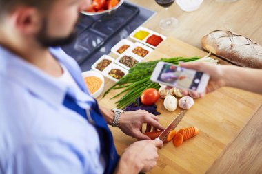 Adam ev mutfağında lezzetli ve sağlıklı yemekler hazırlıyor.