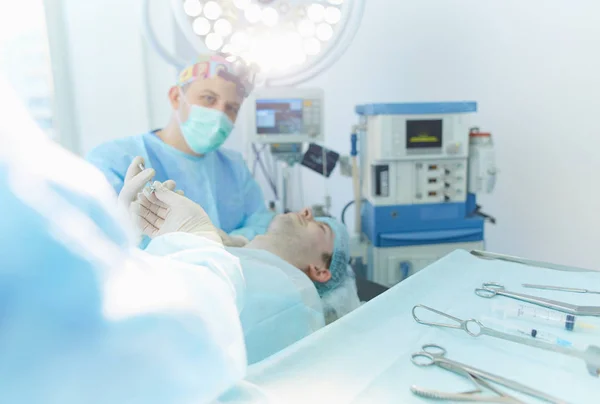 Homem cirurgião no trabalho na sala de cirurgia — Fotografia de Stock