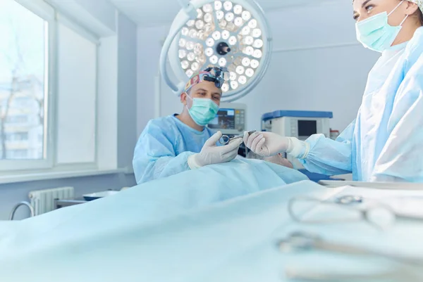 Homem cirurgião no trabalho na sala de cirurgia — Fotografia de Stock