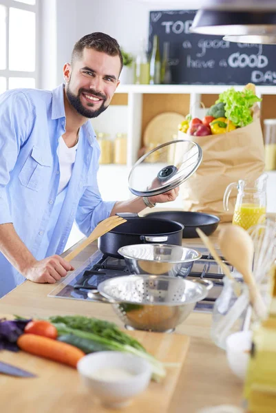 Dijital tablet ve yemek pişirme tarifine uyan bir adam evdeki mutfakta lezzetli ve sağlıklı yemekler pişiriyor. — Stok fotoğraf