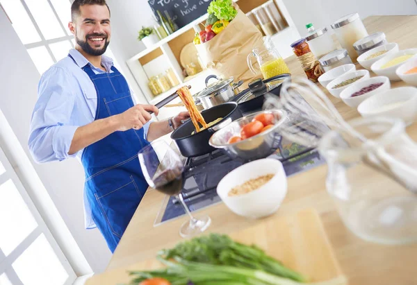 Uomo che prepara cibo delizioso e sano nella cucina di casa — Foto Stock