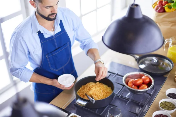 家のキッチンでおいしいと健康食品を準備する男 — ストック写真