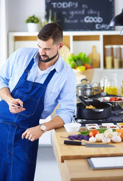 Man som håller papperspåse full av matvaror på köksbakgrund. Shopping och hälsosam mat koncept — Stockfoto