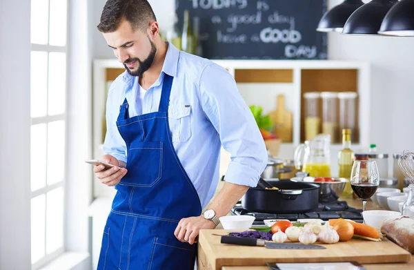 Man som håller papperspåse full av matvaror på köksbakgrund. Shopping och hälsosam mat koncept — Stockfoto