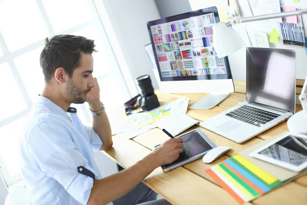 Portrait of young designer sitting at graphic studio in front of laptop and computer while working online. — Stock Photo, Image