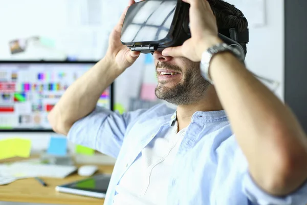 Jovem programador de software masculino testando um novo aplicativo com óculos de realidade virtual 3d no escritório . — Fotografia de Stock