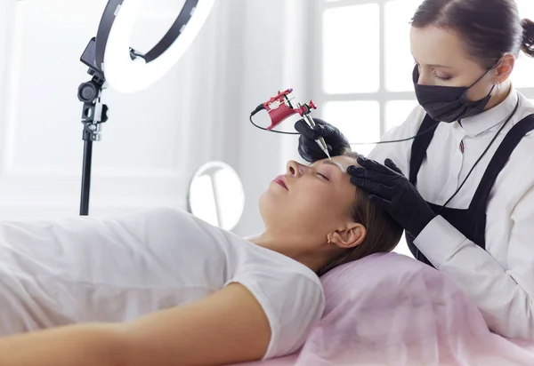 Microblading eyebrows work flow in a beauty salon. Woman having her eye brows tinted — Stock Photo, Image