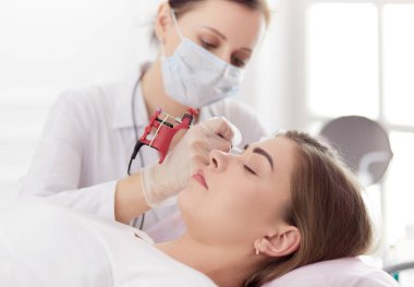 Kırmızı dudaklı genç bir kız kalıcı makyaj, mikro pigmentasyon