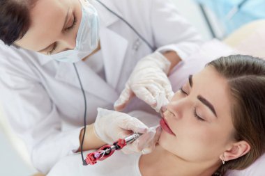 Kırmızı dudaklı genç bir kız kalıcı makyaj, mikro pigmentasyon