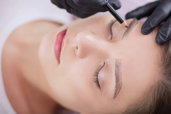 Cosmetólogo aplicando maquillaje permanente en las cejas —  Fotos de Stock