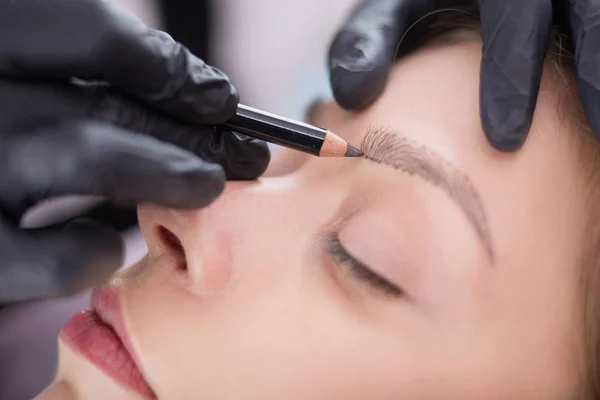 Cosmetólogo aplicando maquillaje permanente en las cejas — Foto de Stock