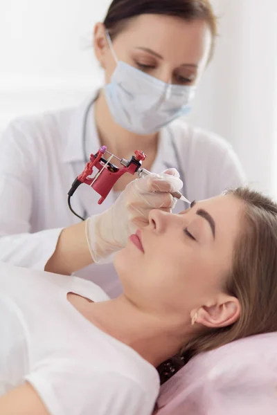 A young girl having red lips permanent makeup, micropigmentation — Stock Photo, Image