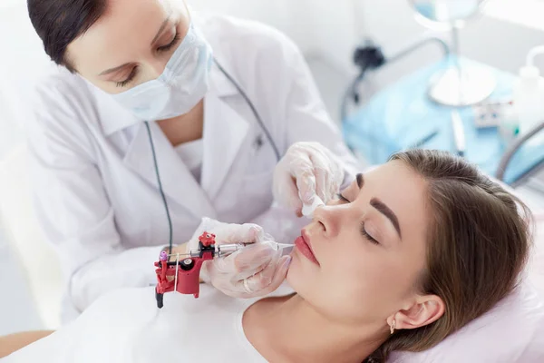 A young girl having red lips permanent makeup, micropigmentation — Stock Photo, Image