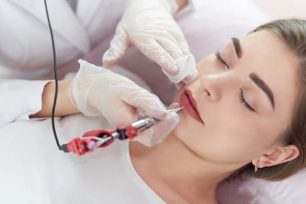 A young girl having red lips permanent makeup, micropigmentation — Stock Photo, Image