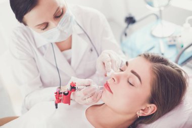 Kırmızı dudaklı genç bir kız kalıcı makyaj, mikro pigmentasyon