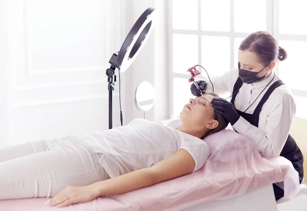 Microblading eyebrows work flow in a beauty salon. Woman having her eye brows tinted — Stock Photo, Image