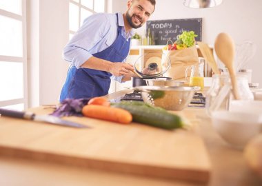 Adam ev mutfağında lezzetli ve sağlıklı yemekler hazırlıyor.