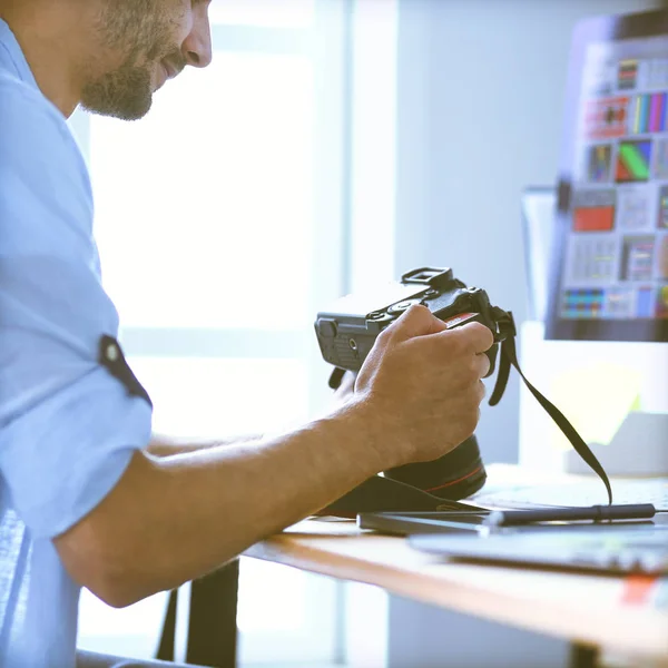 Retrato de jovem designer sentado no estúdio gráfico na frente de laptop e computador enquanto trabalhava online. — Fotografia de Stock