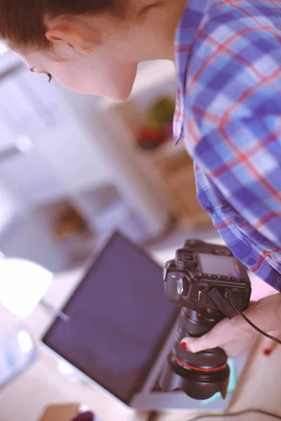 Female photographer sitting on the desk with laptop — Stock Photo, Image