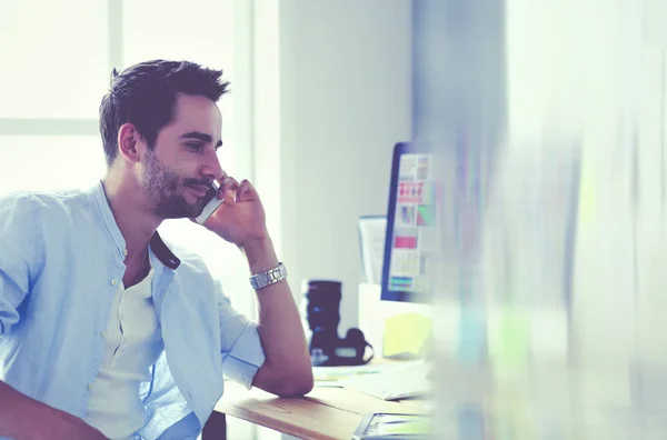 Porträt eines jungen Designers, der im Grafikstudio vor Laptop und Computer sitzt, während er online arbeitet. — Stockfoto