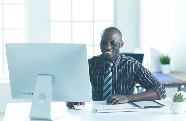 Stilig Afro amerikansk affärsman i klassisk kostym är att använda en laptop och leende medan arbetande i kontor — Stockfoto