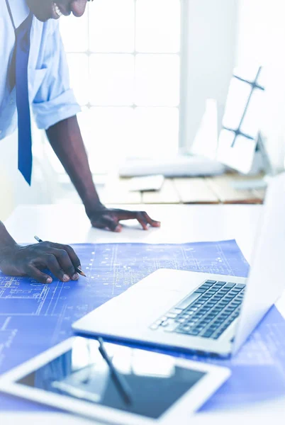 Arquitecto afroamericano trabajando con computadoras y planos en la oficina —  Fotos de Stock