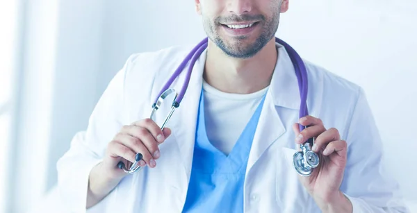 Retrato médico masculino joven y confiado de pie en el consultorio médico — Foto de Stock