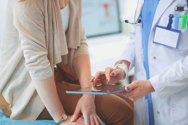 Dokter en patiënt bespreken iets terwijl ze aan tafel zitten. Geneeskunde en gezondheidszorg. Dokter en patiënt — Stockfoto