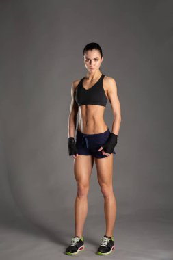 Gri arka planda izole edilmiş güzel ve sağlıklı bir spor kız portresi