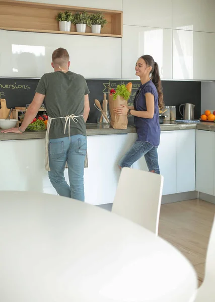 Красивая молодая пара веселится дома на кухне — стоковое фото