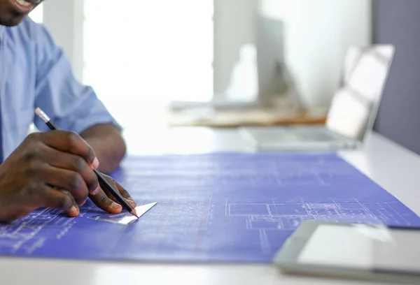 Arquitecto afroamericano trabajando con computadoras y planos en la oficina —  Fotos de Stock