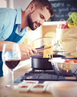 Adam ev mutfağında lezzetli ve sağlıklı yemekler hazırlıyor.