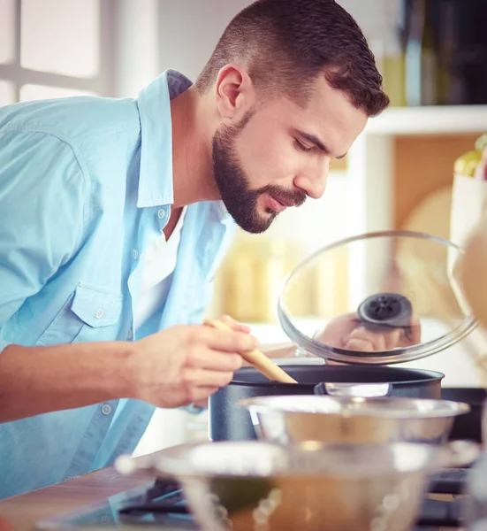 Man volgens recept op digitale tablet en lekker en gezond koken in de keuken thuis — Stockfoto