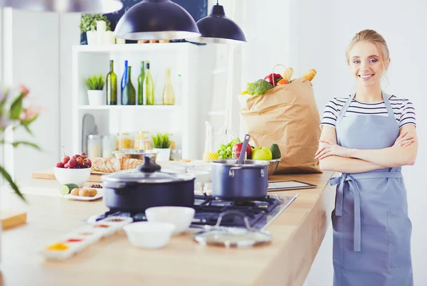 Schöne junge Frau kocht zu Hause in der Küche — Stockfoto