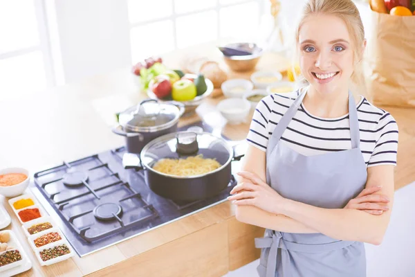 Jovem mulher de pé perto da mesa na cozinha — Fotografia de Stock