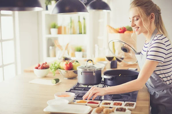 Mooie jonge vrouw koken in keuken thuis — Stockfoto