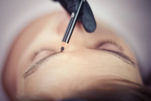 Cosmetologist applying permanent make up on eyebrows — Stock Photo, Image