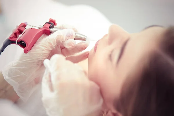 Een jong meisje met rode lippen permanente make-up, micropigmentatie — Stockfoto